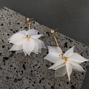 Elegant white crystal flower drop earrings with gold studs on a natural stone base