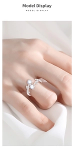 Detail of a 925 sterling silver vine ring with light blue gemstones on a female finger