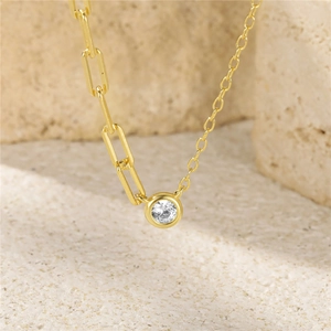 Gold asymmetrical paperclip chain necklace with a round sparkling cubic zirconia pendant