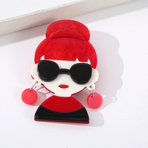 Detailed close-up of a pop art acrylic brooch featuring a girl with red hair and sunglasses