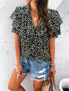 Detail of V-neck floral top with yellow prints and ruffled sleeves on model