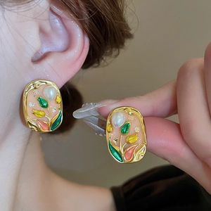 Detailed close-up of tulip enamel earrings with pearl accents on a female model