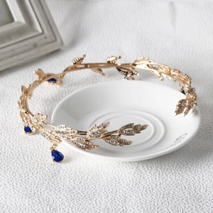 Detail of gold leaf bridal tiara with rhinestones and blue water drop forehead pendant
