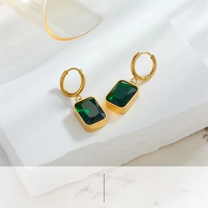 Detail of vintage gold hoop earrings with emerald green square gemstone pendants