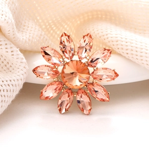Gros plan sur l'accessoire floral en cristal orange avec monture dorée étincelante