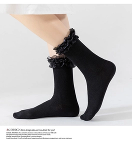 Detail of black cotton calf socks featuring multi-layer organza lace ruffles and ribbed texture