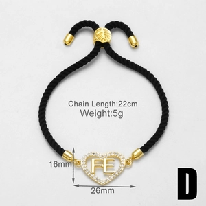 Detailansicht Gold-Herzanhänger mit FE-Schriftzug an schwarzem geflochtenem Armband