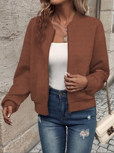 Detail of brown quilted bomber jacket featuring stand collar and zipper closure