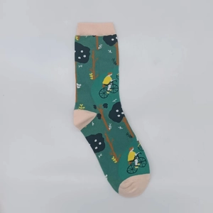 Detail of green cotton socks featuring jacquard trees and a cyclist illustration