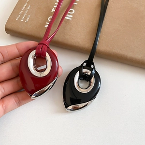 Close-up of a deep red water drop pendant necklace on a premium leather cord strap