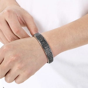Detailed close-up of Men's Viking Wolf Head bangle with Celtic patterns on wrist