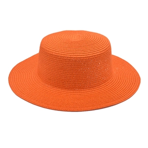 Detailed close-up of the fine woven texture on an orange flat top boater straw hat