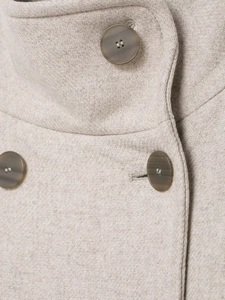 Dettaglio del cappotto di lana avena con bottoni a doppio petto e trama in saia