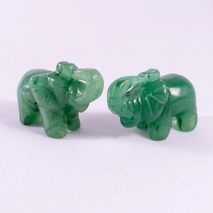 Hand-carved green jade elephant figurine with natural texture on a white background