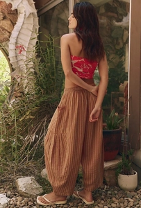 Detail of striped linen-textured trousers featuring an elastic waist and side pockets