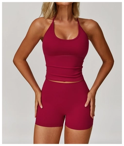 Detail of high-waist yoga shorts and halter top in dark magenta matte elastic fabric