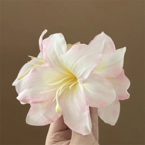 Close-up of white and pink lily hair claw clip with yellow stamens for women's hair