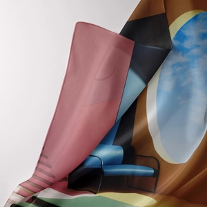 Close-up of silky artistic tapestry fabric showing vibrant surrealist patterns and texture