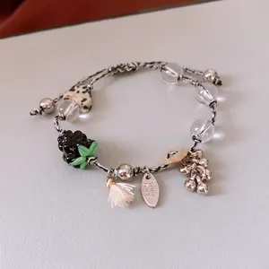 Handmade beaded bracelet with heart stone charms, white tassel, and woven rope strap
