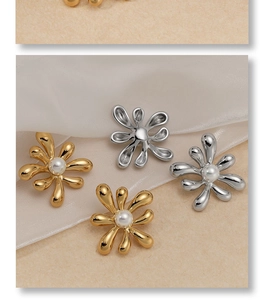 Detailed view of flower earrings with white pearls in gold and silver polished finish