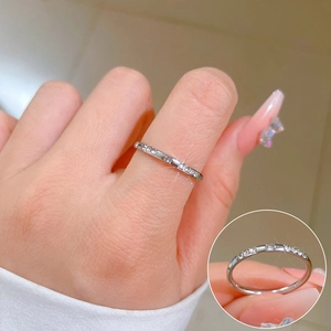 Detailed close-up of a slim silver eternity ring with micro-pave crystals on model's finger