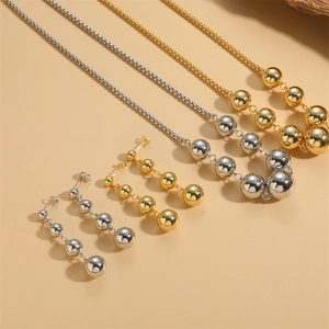 Golden and silver beaded ball jewelry set featuring necklaces and matching earrings