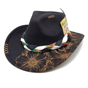 Detail of black wool felt cowboy hat featuring gold floral prints and woven ethnic band
