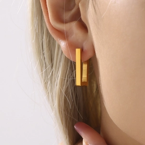 Rectangular geometric earrings in 18K gold plated stainless steel on a female model