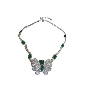 Silver butterfly necklace with green emeralds and rhinestones on a white background