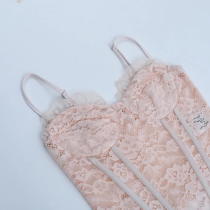 Gros plan du caraco en dentelle rose avec broderie florale complexe et maille fine