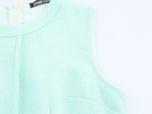 Detail of mint green sleeveless dress with tweed texture and hidden back zipper