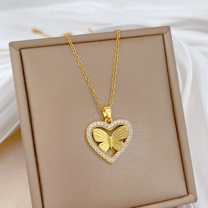 Macro detail of gold-plated butterfly heart pendant with sparkling pavé crystals