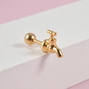 Macro detail of gold faucet shaped stud earring with screw ball back on geometric props