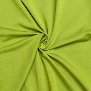 Macro shot of green ribbed fabric showing detailed texture and soft pleats on jumpsuit
