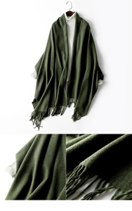 Close-up of green wool blend shawl showing fringe tassels and thick knit texture