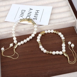Close-up of adjustable bead bracelets with pearl accents and heart-shaped charms