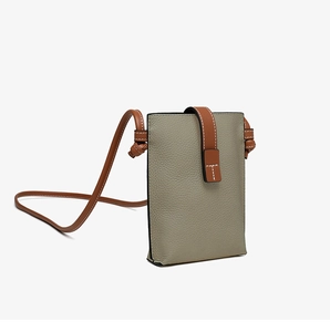 Detail view of sage green lychee grain leather phone bag with brown knotted shoulder strap