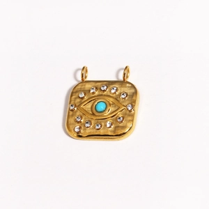 Detailed macro of golden evil eye pendant with turquoise stone and sparkling rhinestones