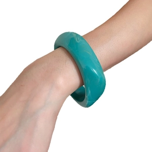 Vintage gold-plated wide resin bangle with mother-of-pearl inlay style on a model wrist