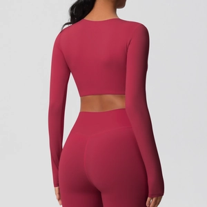Vue arrière de l'ensemble de yoga rose foncé avec haut court à manches longues et legging