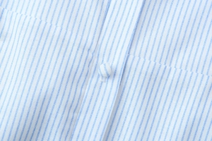 Detailaufnahme des blau-weiß gestreiften Stoffes mit passendem stoffbezogenem Knopf