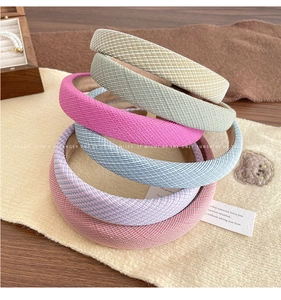 Close-up of five colorful tweed sponge headbands in candy colors with woven fabric texture