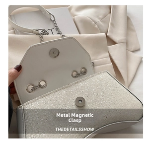 Detail of a silver sequined shoulder bag showing the secure metal magnetic closure buckle