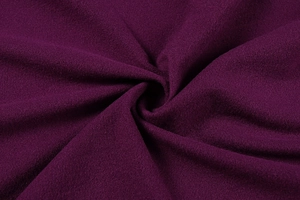 Close-up of deep purple knit fabric showing soft plush texture and draped fold detail