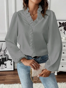 Close-up of elegant ruffled V-neckline and sleeve details on a gray chiffon blouse