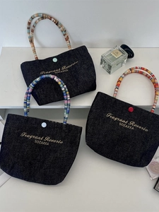 Mini denim tote bags with colorful beaded handles and floral embroidery on a white shelf