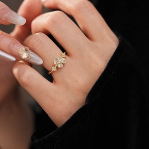Macro shot of gold plated flower ring with sparkling zircon stones worn on finger
