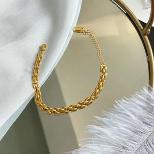 Elegant 18K gold-plated watchband style chain bracelet for women on a mirrored surface