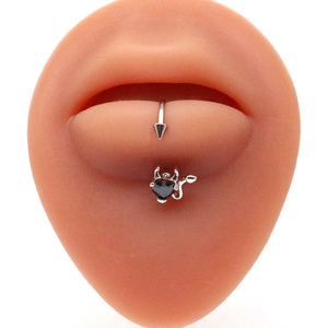 Detail view of silver stainless steel lip stud with black devil heart on a lip model