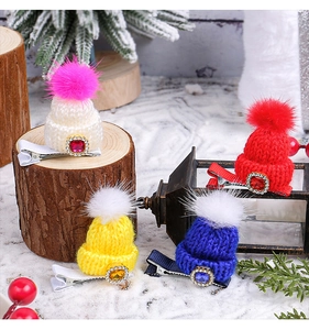 Detailed view of colorful knitted Christmas hat hair clips with fur balls and rhinestones